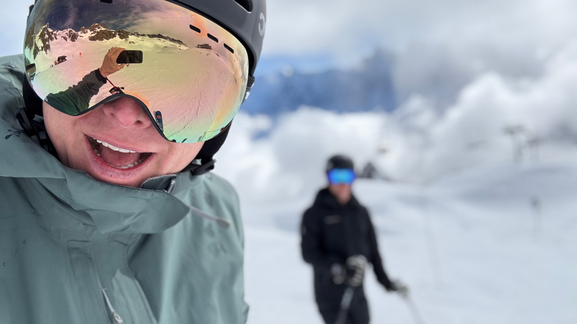 Skidåkare i Årefjällen med snöiga berg speglade i goggles